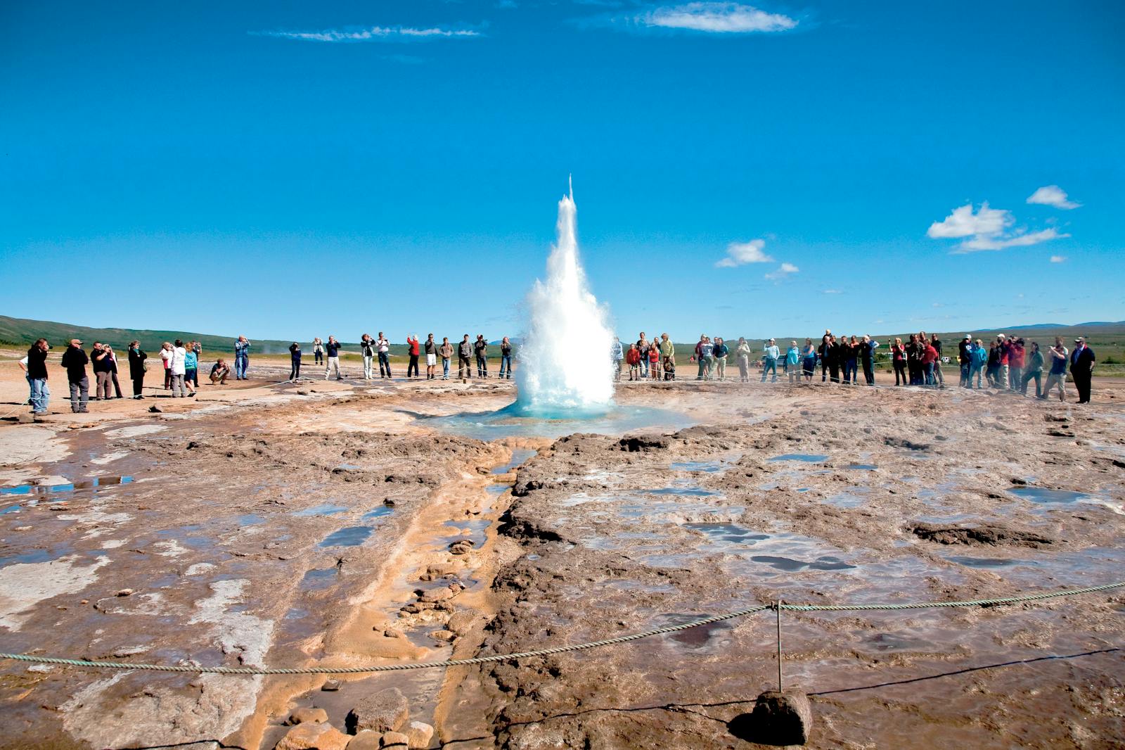 Mulțime observând erupția unui geyser pe Circuitul de Aur
